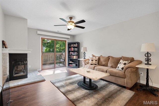 12958 Bryce Canyon Dr Unit C, Maryland Heights, MO 63043 - living room featuring ceiling fan, wood finished floors, a brick fireplace, and baseboards
