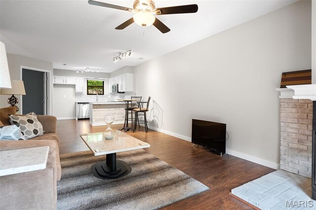 12958 Bryce Canyon Dr Unit C, Maryland Heights, MO 63043 - living room with dark wood-type flooring, a ceiling fan, a fireplace, and baseboards