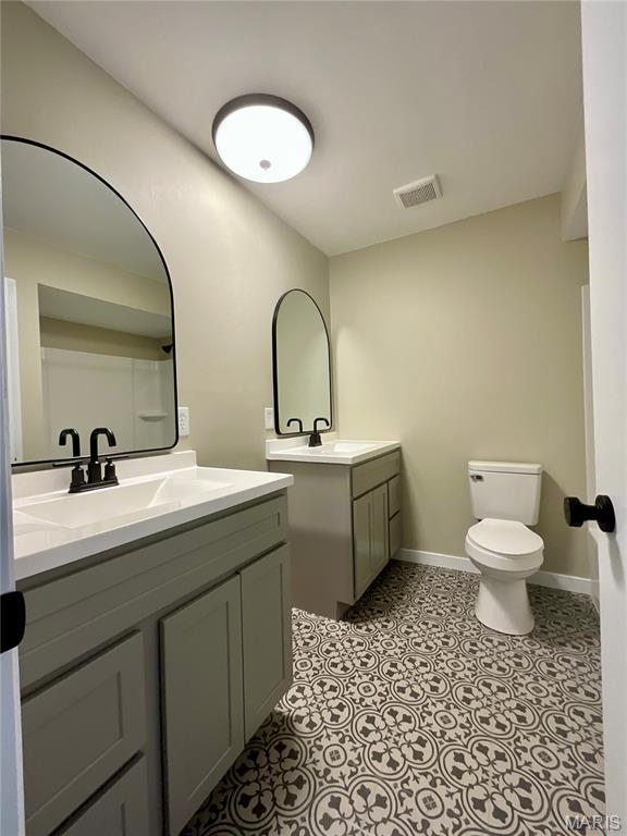 3919 Bellvue Dr, Saint Peters, MO 63376 - bathroom featuring two vanities and baseboards