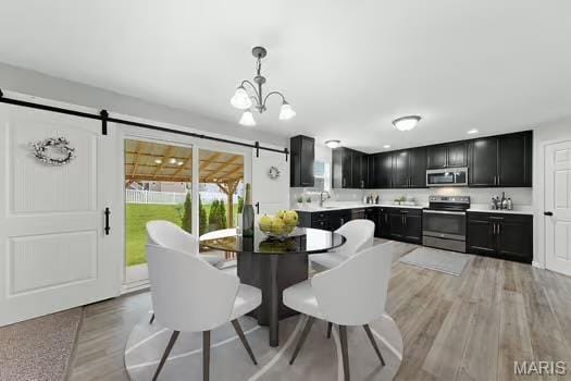 3169 Willow Point Dr, Imperial, MO 63052 - dining area featuring a barn door, light wood-style flooring, and a chandelier