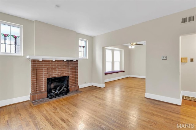 6026 Waterman Ave Unit 3E, Saint Louis, MO 63112 - unfurnished living room featuring plenty of natural light, a fireplace, wood finished floors, and ceiling fan