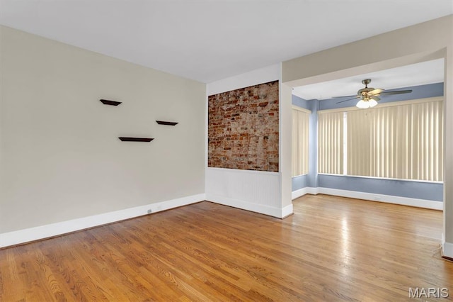 6026 Waterman Ave Unit 3E, Saint Louis, MO 63112 - unfurnished room featuring wood finished floors, a ceiling fan, baseboards, and a wainscoted wall