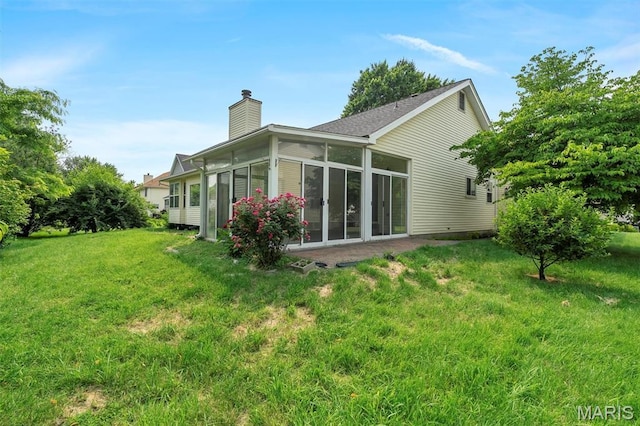 1045 Sprinters Row Dr, Florissant, MO 63034 - rear view of house featuring a chimney, a sunroom, and a yard