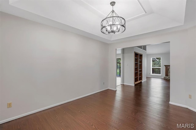 1045 Sprinters Row Dr, Florissant, MO 63034 - unfurnished room featuring a tray ceiling, a chandelier, dark wood-style flooring, and baseboards