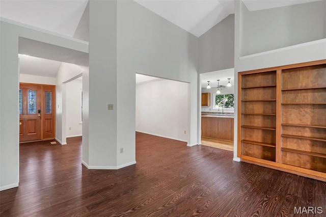 1045 Sprinters Row Dr, Florissant, MO 63034 - unfurnished living room featuring high vaulted ceiling, dark wood-style floors, baseboards, and a sink