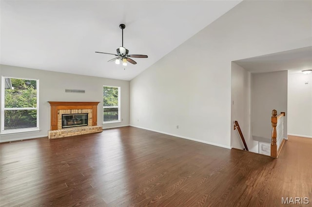 1045 Sprinters Row Dr, Florissant, MO 63034 - unfurnished living room featuring plenty of natural light, ceiling fan, dark wood-style floors, high vaulted ceiling, and a brick fireplace