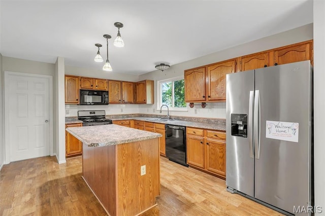 1045 Sprinters Row Dr, Florissant, MO 63034 - kitchen with black appliances, a sink, light wood-style floors, and hanging light fixtures