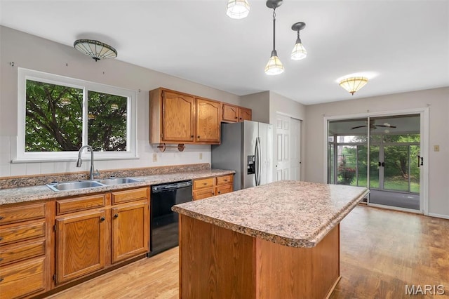 1045 Sprinters Row Dr, Florissant, MO 63034 - kitchen with dishwasher, stainless steel fridge, a sink, light wood-style floors, and brown cabinets