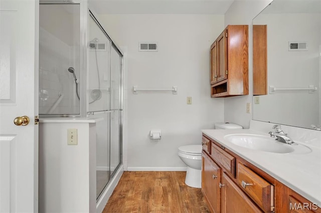 1045 Sprinters Row Dr, Florissant, MO 63034 - bathroom with vanity, a stall shower, toilet, wood finished floors, and baseboards