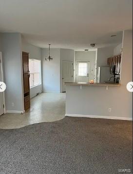 876 Mildred Ave, Cahokia, IL 62206 - kitchen with plenty of natural light, a peninsula, a kitchen breakfast bar, and baseboards