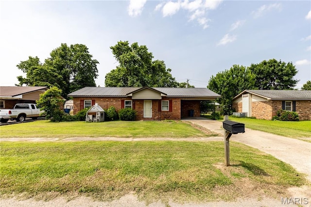 141 Saint Catherine Ln, New Madrid, MO 63869 - ranch-style house with concrete driveway, brick siding, an attached carport, and a front yard