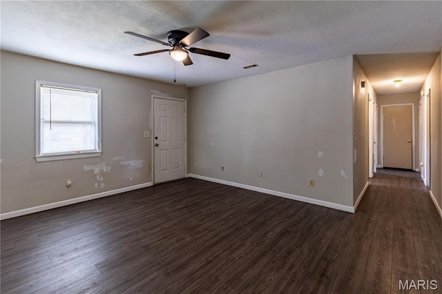 141 Saint Catherine Ln, New Madrid, MO 63869 - spare room featuring dark wood-style floors, a ceiling fan, a textured ceiling, and baseboards