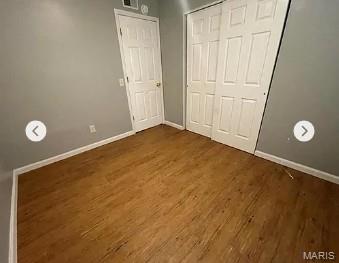 862 Saint Benedict, Cahokia, IL 62206 - unfurnished bedroom featuring baseboards, dark wood-type flooring, and a closet