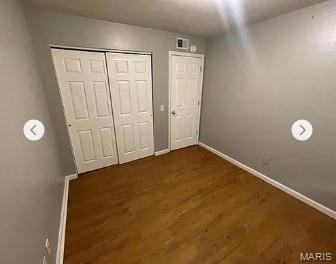 862 Saint Benedict, Cahokia, IL 62206 - unfurnished bedroom with baseboards, dark wood-type flooring, and a closet