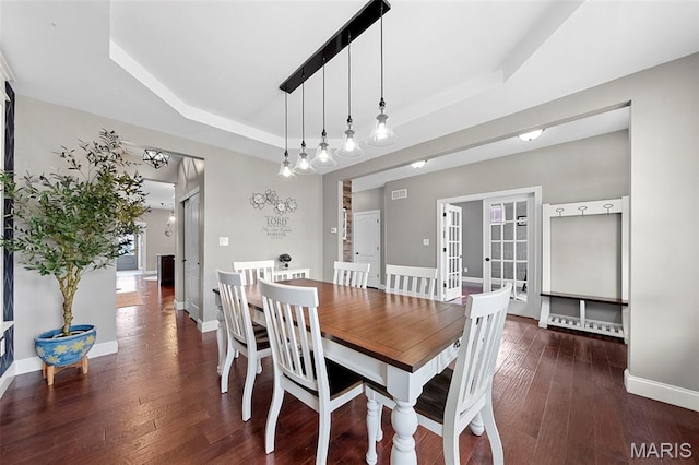 3204 Hadrian St, Saint Charles, MO 63301 - dining room featuring a tray ceiling, wood finished floors, and baseboards