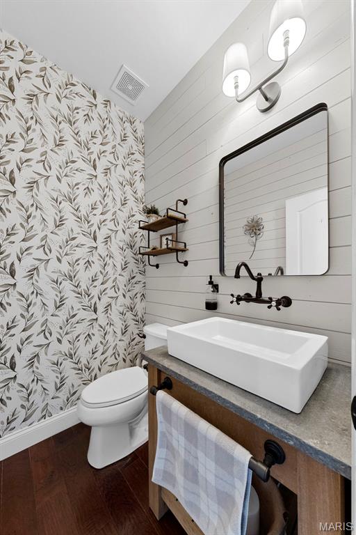 3204 Hadrian St, Saint Charles, MO 63301 - full bathroom with wallpapered walls, vanity, toilet, wood finished floors, and baseboards