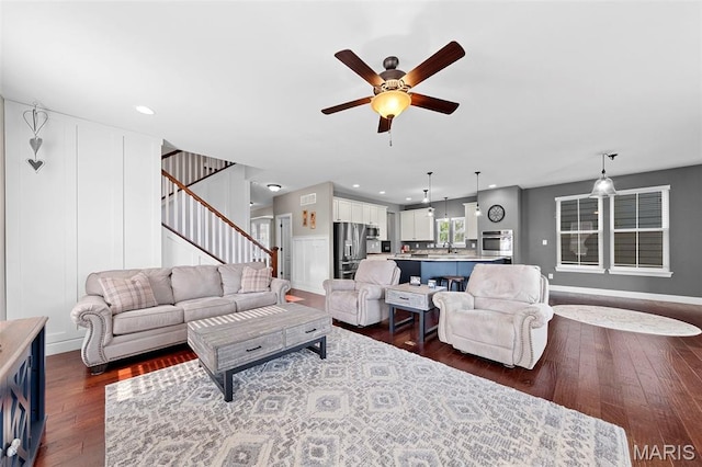 3204 Hadrian St, Saint Charles, MO 63301 - living room featuring ceiling fan, stairway, dark wood-type flooring, recessed lighting, and baseboards
