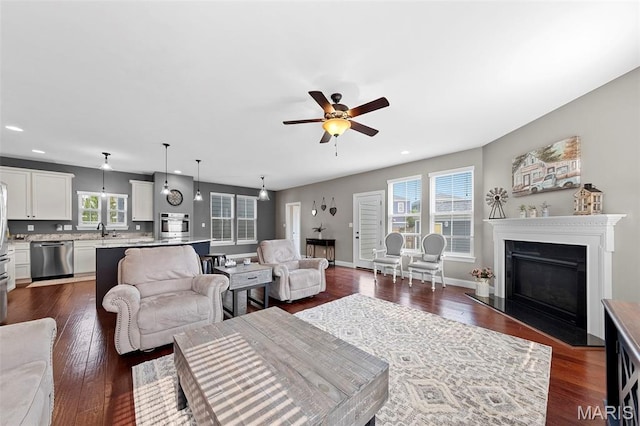 3204 Hadrian St, Saint Charles, MO 63301 - living area with a ceiling fan, recessed lighting, dark wood-type flooring, a fireplace with flush hearth, and baseboards