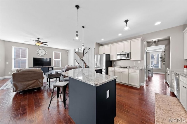 3204 Hadrian St, Saint Charles, MO 63301 - kitchen featuring stainless steel appliances, a breakfast bar, open floor plan, white cabinets, and recessed lighting