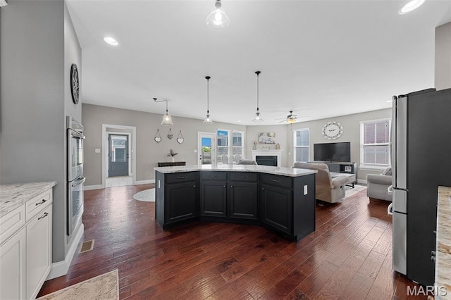 3204 Hadrian St, Saint Charles, MO 63301 - kitchen with appliances with stainless steel finishes, open floor plan, ceiling fan, a kitchen island, and dark wood finished floors