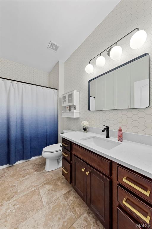 3204 Hadrian St, Saint Charles, MO 63301 - full bath featuring vanity, toilet, stone finish floors, and a shower with shower curtain