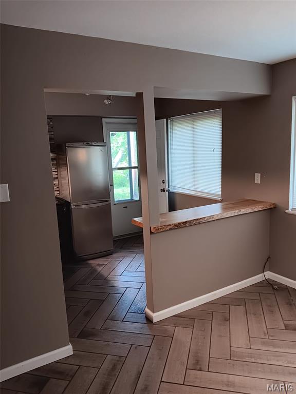 7731 Hazelcrest Dr Unit B, Hazelwood, MO 63042 - kitchen with stainless steel fridge, baseboards, and light countertops