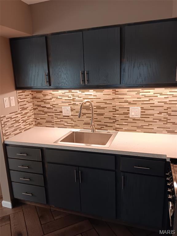 7731 Hazelcrest Dr Unit B, Hazelwood, MO 63042 - kitchen with a sink, light countertops, and decorative backsplash