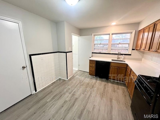 170 Ruth Dr, Florissant, MO 63031 - kitchen with black appliances, light wood-type flooring, brown cabinets, a sink, and wainscoting