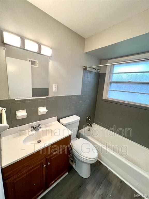 170 Ruth Dr, Florissant, MO 63031 - bathroom with tile walls, wood finished floors, shower / washtub combination, toilet, and vanity