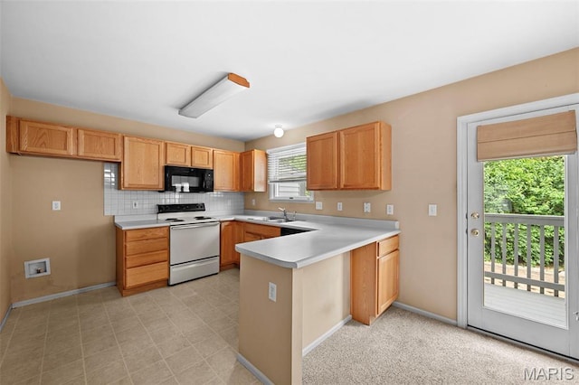 4505 Sherman Park Dr, Saint Charles, MO 63303 - kitchen with black microwave, white range with electric stovetop, a peninsula, light countertops, and baseboards