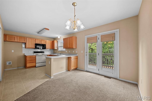 4505 Sherman Park Dr, Saint Charles, MO 63303 - kitchen featuring white range with electric cooktop, black microwave, a chandelier, light countertops, and a peninsula