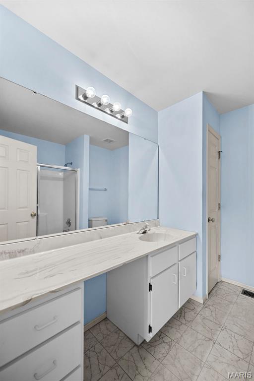 4505 Sherman Park Dr, Saint Charles, MO 63303 - full bathroom with vanity, marble look tiles, a stall shower, and toilet