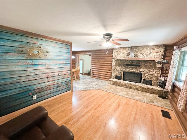 1 Timber Ln, Salem, MO 65560 - living area featuring a ceiling fan, wood finished floors, rustic walls, and a fireplace