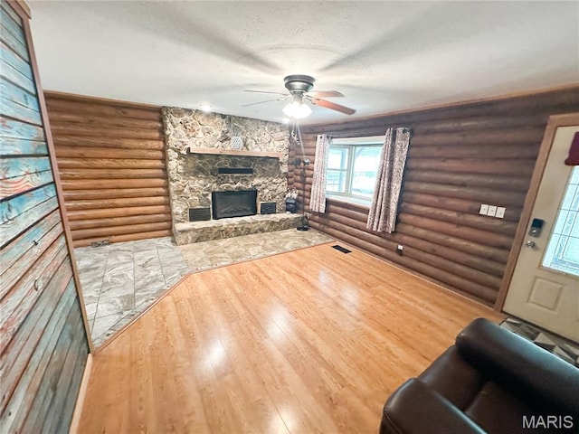 1 Timber Ln, Salem, MO 65560 - living area featuring rustic walls, a stone fireplace, ceiling fan, wood finished floors, and a textured ceiling