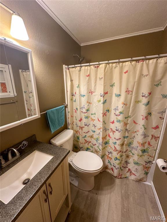 1 Timber Ln, Salem, MO 65560 - bathroom with wood finished floors, a textured ceiling, vanity, crown molding, and toilet