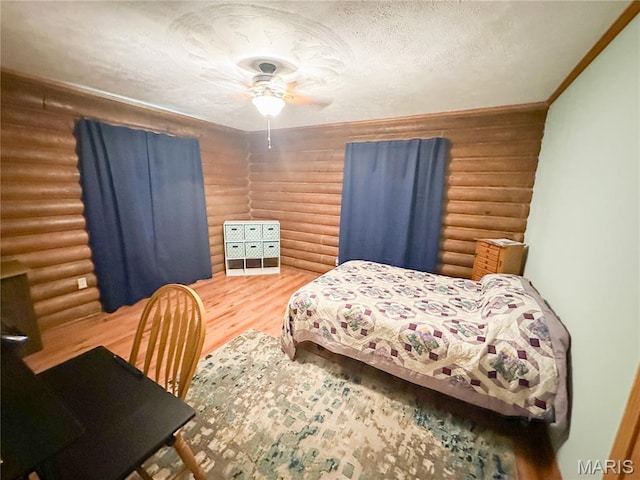 1 Timber Ln, Salem, MO 65560 - bedroom with log walls, wood finished floors, ornamental molding, a textured ceiling, and a ceiling fan