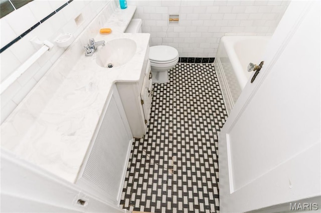 7360 Dartmouth Ave, University City, MO 63130 - bathroom with tile patterned floors, tile walls, a tub to relax in, and vanity