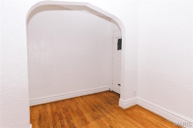 7360 Dartmouth Ave, University City, MO 63130 - empty room featuring arched walkways and light wood-type flooring