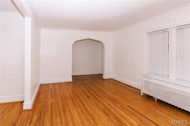 7360 Dartmouth Ave, University City, MO 63130 - empty room with radiator, wood finished floors, ornamental molding, and arched walkways