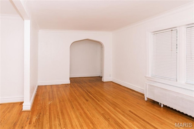 7360 Dartmouth Ave, University City, MO 63130 - unfurnished room with radiator heating unit, ornamental molding, light wood-style floors, and arched walkways