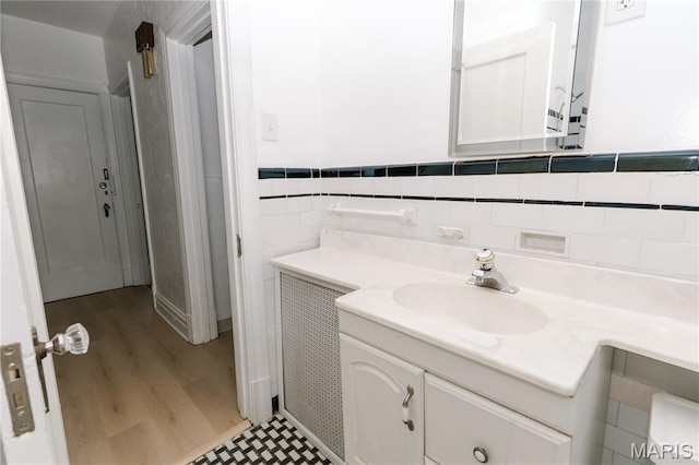 7360 Dartmouth Ave, University City, MO 63130 - bathroom featuring vanity, wood finished floors, tile walls, and wainscoting