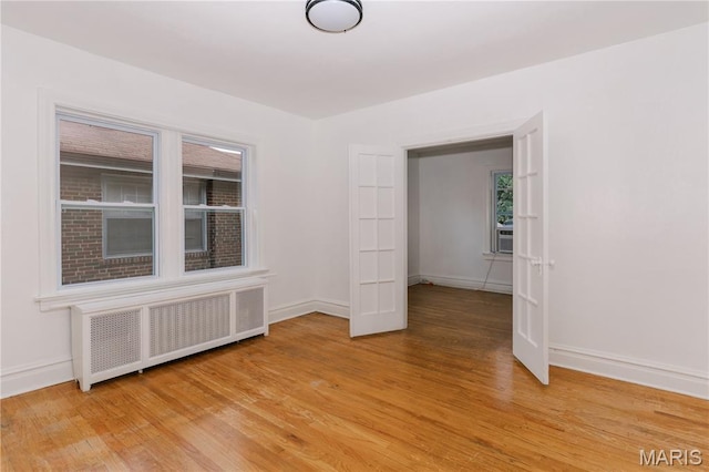7360 Dartmouth Ave, University City, MO 63130 - spare room featuring radiator and light wood-style floors