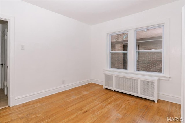 7360 Dartmouth Ave, University City, MO 63130 - unfurnished room featuring radiator heating unit and light wood-type flooring