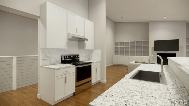 31634 Dogwood Ln, Foristell, MO 63348 - kitchen featuring stainless steel range oven, under cabinet range hood, a sink, white cabinets, and decorative backsplash