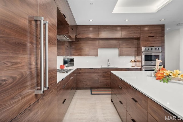 150 Carondelet Plz Unit 702, Clayton, MO 63105 - kitchen featuring modern cabinets, stainless steel appliances, light countertops, custom exhaust hood, and recessed lighting
