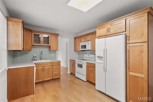 9177 Robin Ct, Brentwood, MO 63144 - kitchen with white appliances, a sink, light wood-style floors, tasteful backsplash, and light countertops