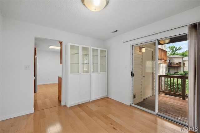 9177 Robin Ct, Brentwood, MO 63144 - spare room featuring light wood-style flooring, baseboards, and a textured ceiling