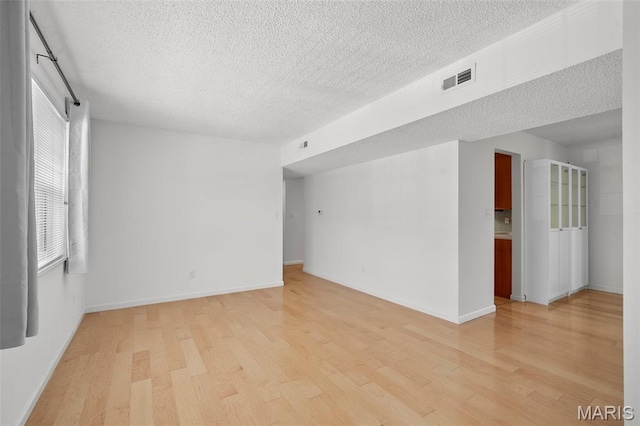 9177 Robin Ct, Brentwood, MO 63144 - unfurnished room with light wood-type flooring, a textured ceiling, and baseboards