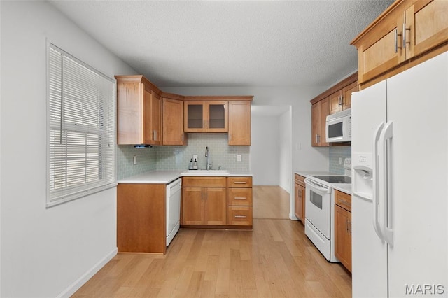 9177 Robin Ct, Brentwood, MO 63144 - kitchen with white appliances, a sink, light wood-style flooring, backsplash, and a textured ceiling
