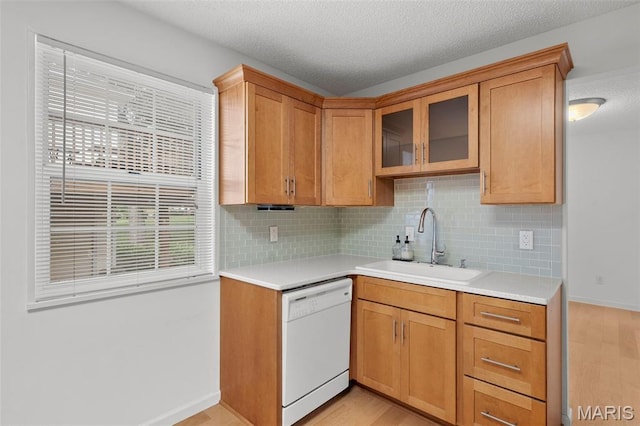 9177 Robin Ct, Brentwood, MO 63144 - kitchen featuring white dishwasher, a sink, light countertops, decorative backsplash, and a textured ceiling